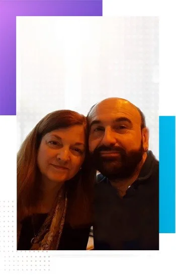 Janet Swerdlow on the left and Stewart A. Swerdlow on the right, smiling together within a purple-and-blue graphic frame